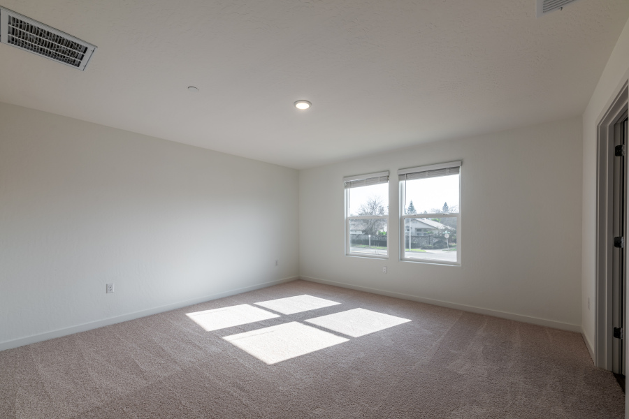 A room with a window and a rug.