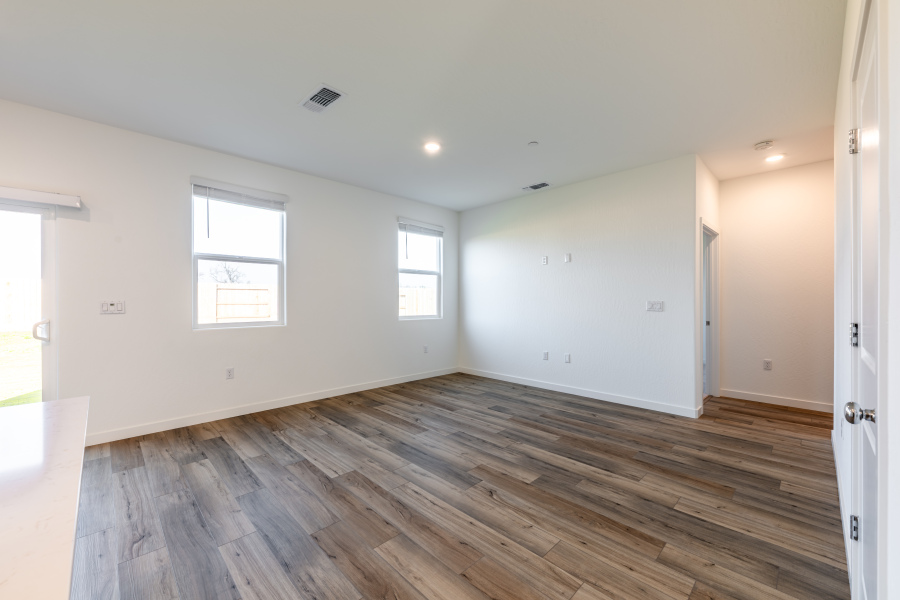 A room with a wood floor and windows.