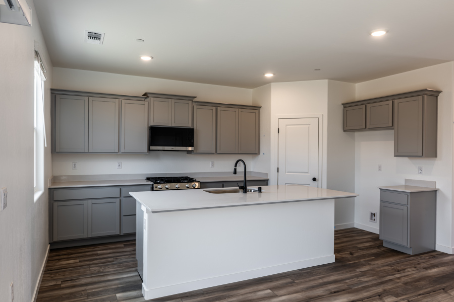 A kitchen with white cabinets.