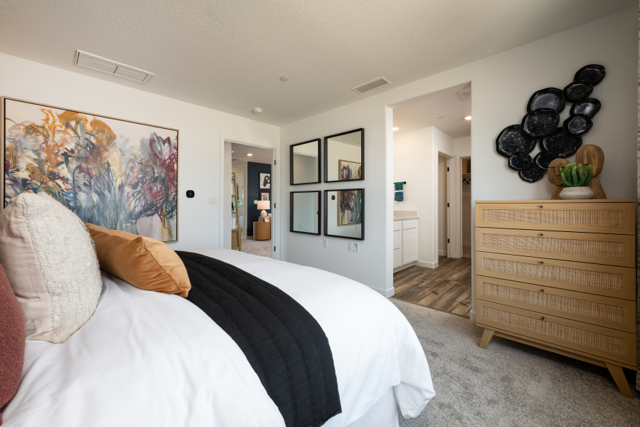 A bedroom with a bed and a dresser.