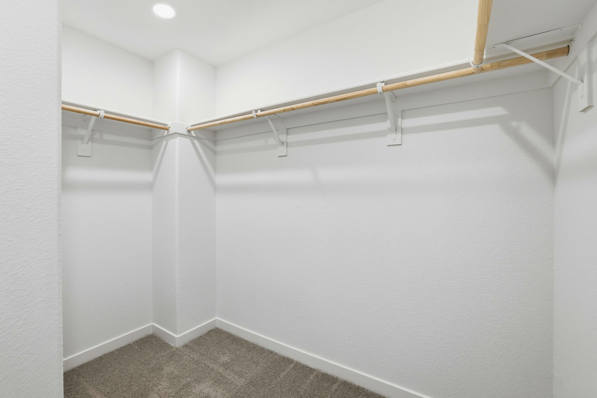 A white wall with a metal bar.