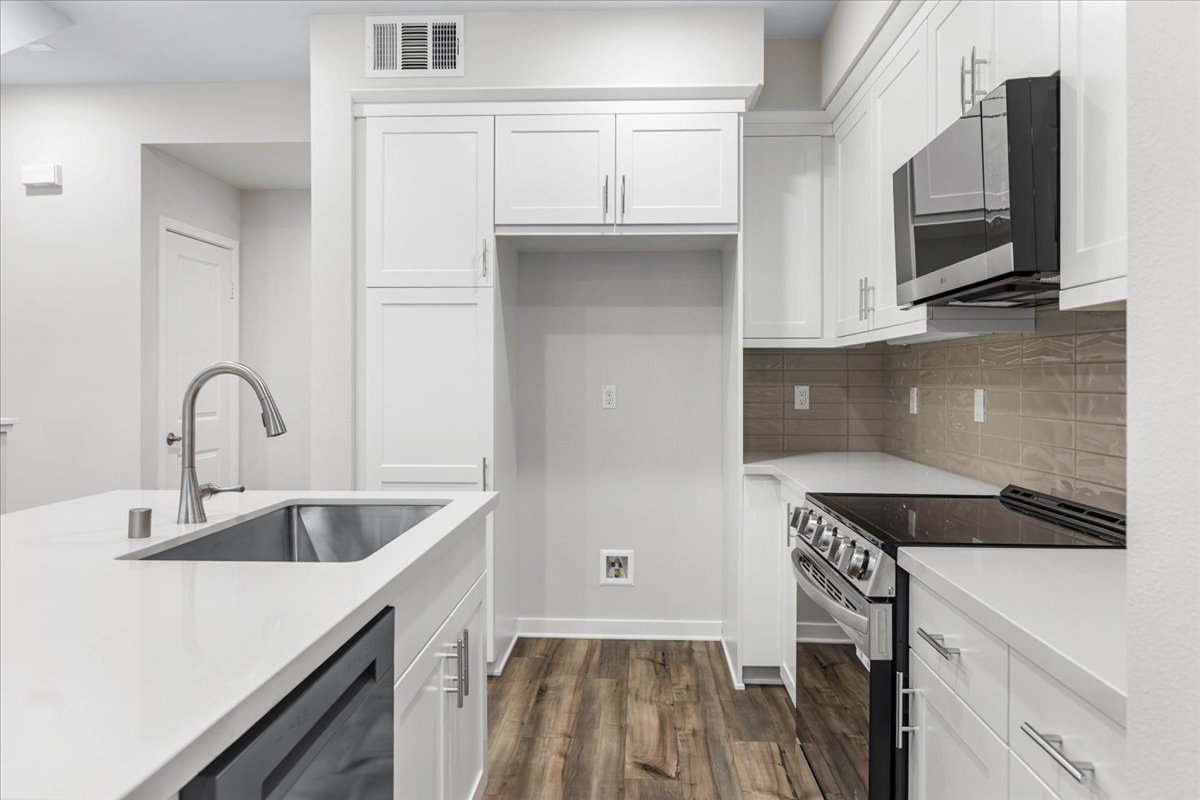 A kitchen with white cabinets.