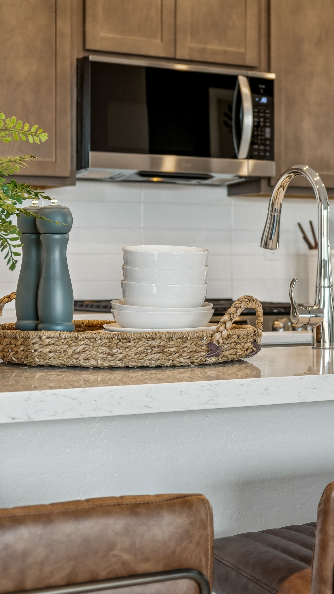 Burlap medium wood grain kitchen cabinets with 3cm white cosentino marble and an under-mounted kitchen sink with walk in pantry, cream backsplash & spacious kitchen island - New construction homes for sale Goodyear AZ Resort style amenities & founder incentives to the lucky few first homeowners.