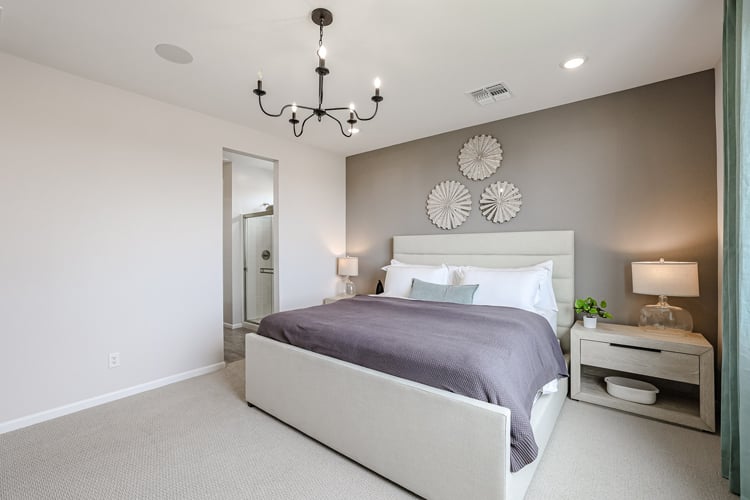 A bedroom with a bed and lamps.