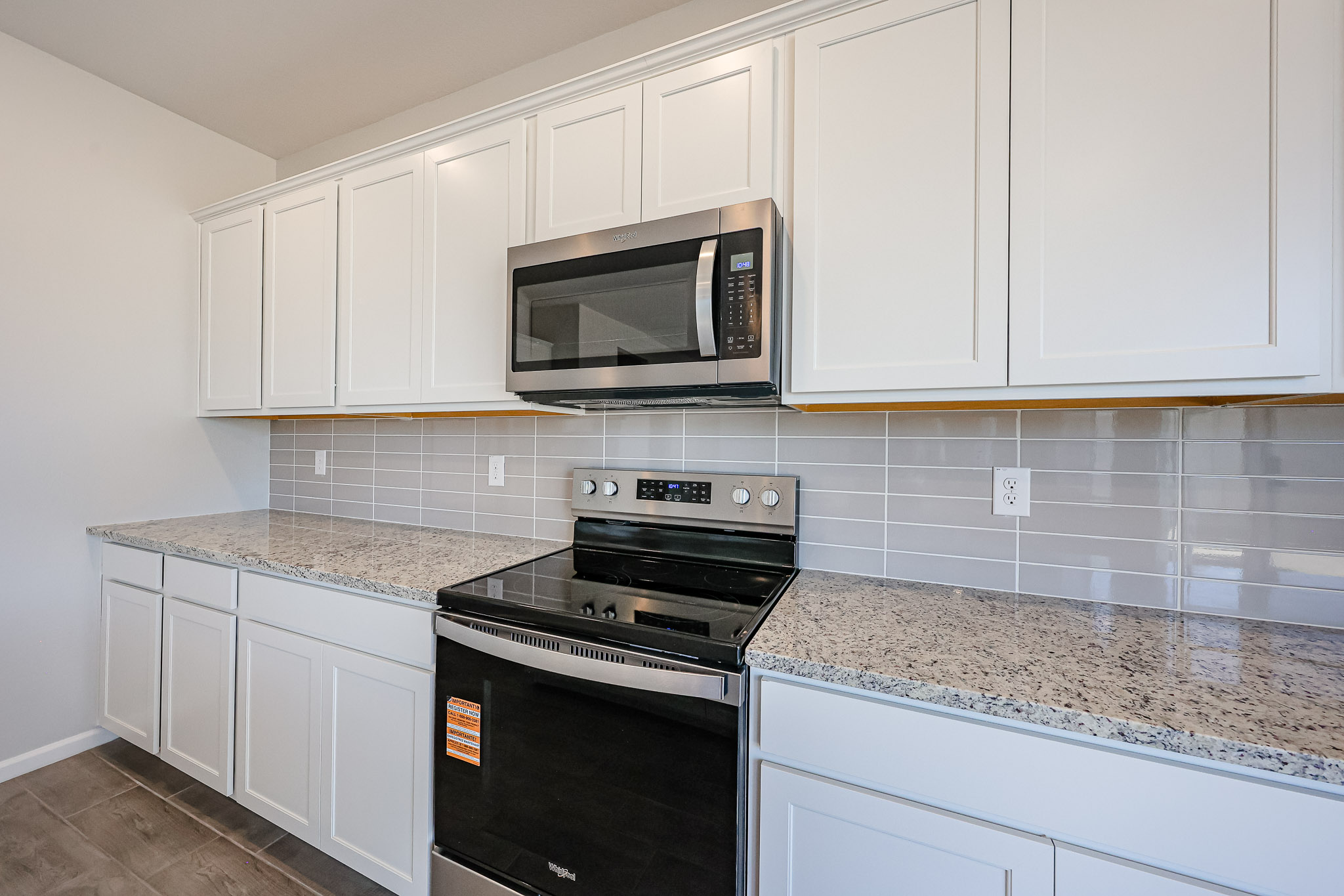 A kitchen with white cabinets.