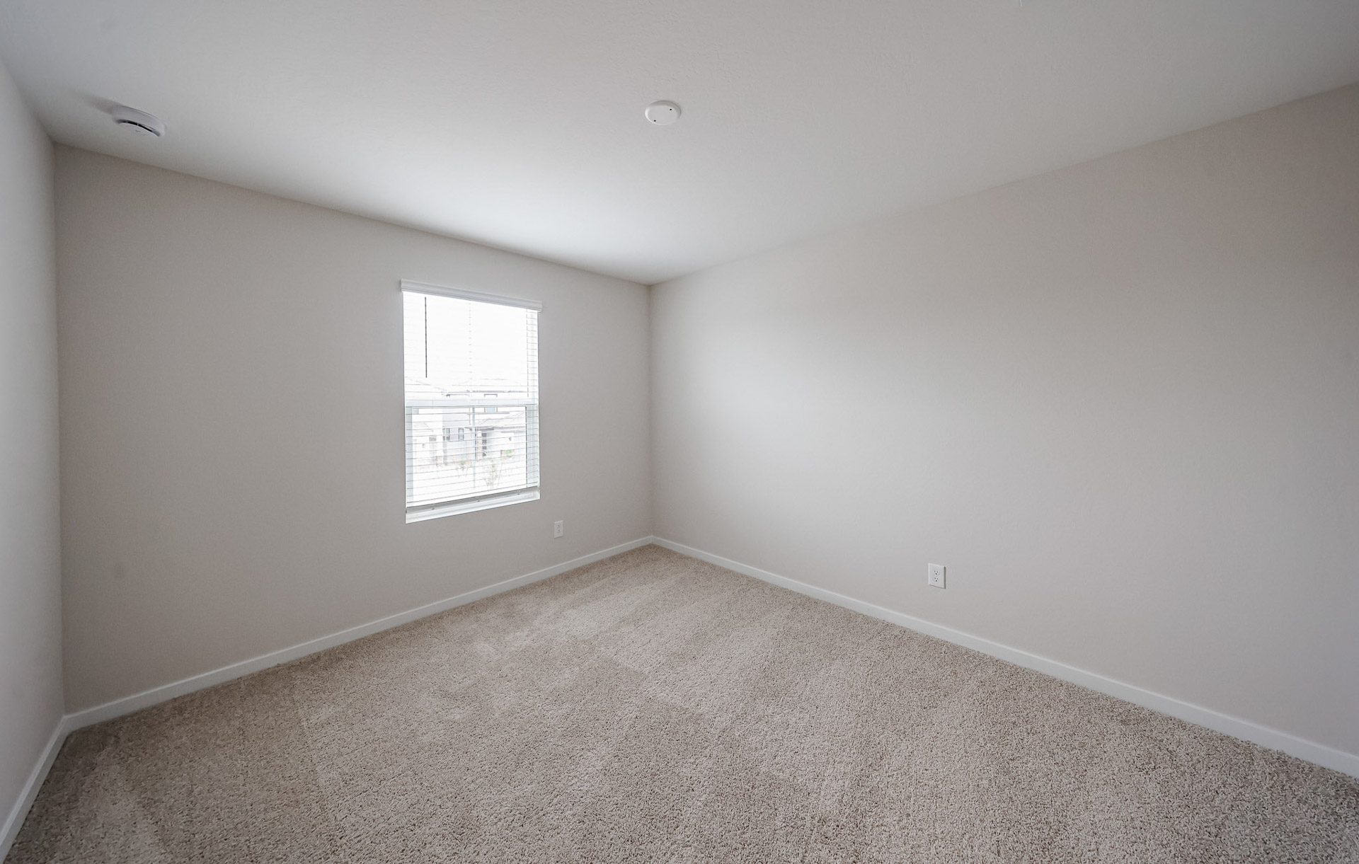 A room with a carpet and a window.