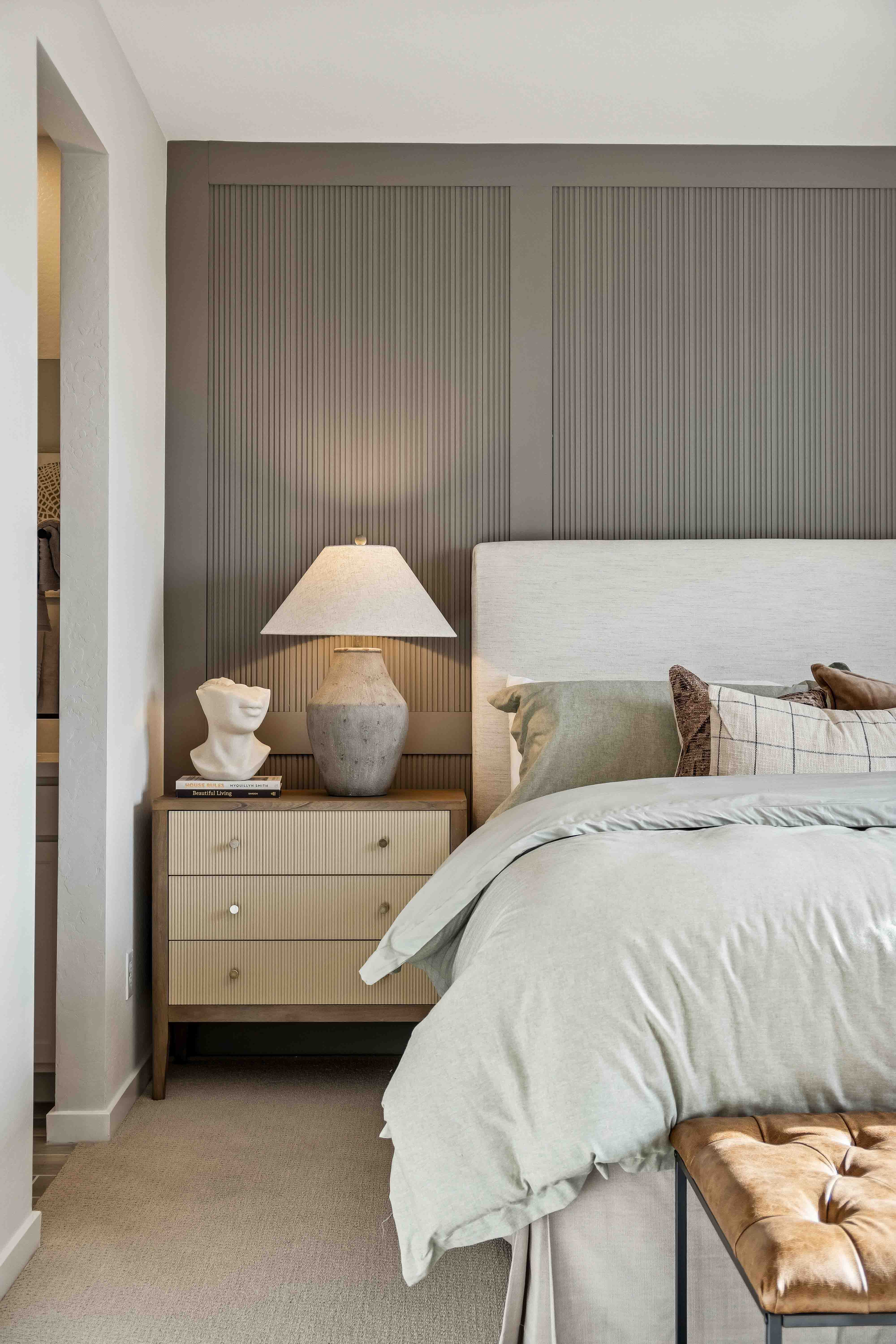 Interior photo of the primary bedroom editorial close-up photo of bed, lamp and decor with textured elements for added depth to this wholesome home design in the model home Alder floor plan in The Highlands Collection at Skyline Village in San Tan Valley, Arizona by Century Communities New Construction Homes for Sale in Phoenix