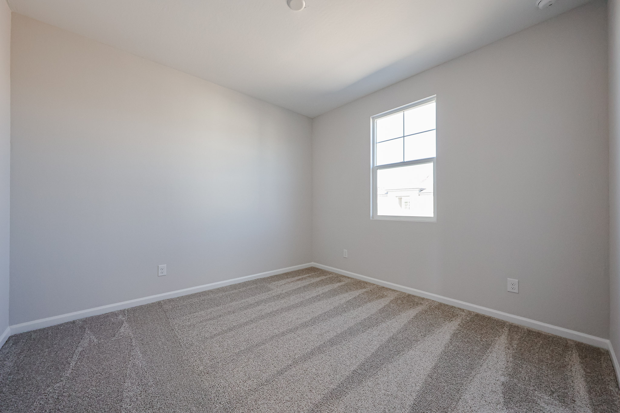 A room with a window and a carpet.