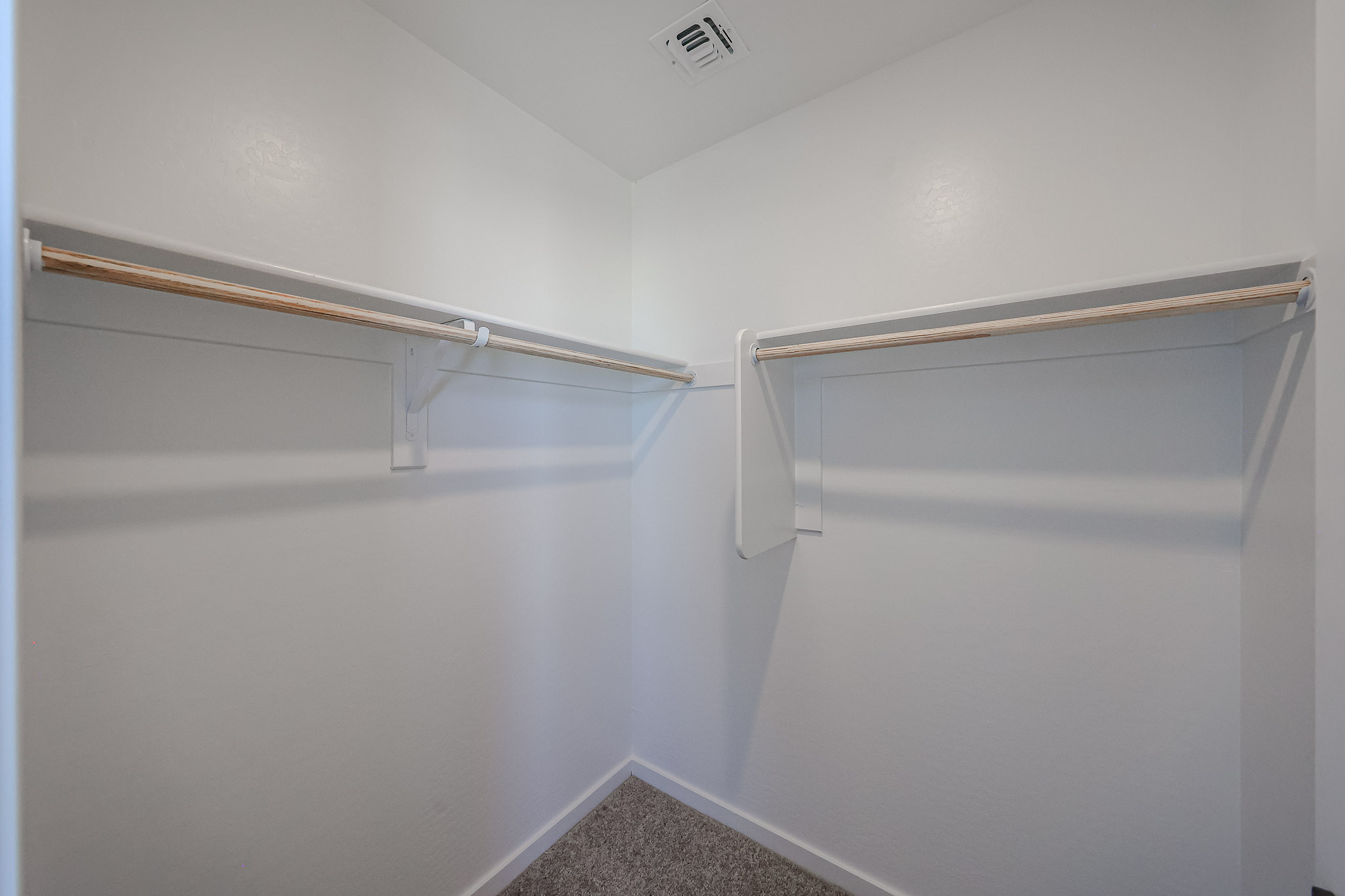 A white wall with a metal bar.