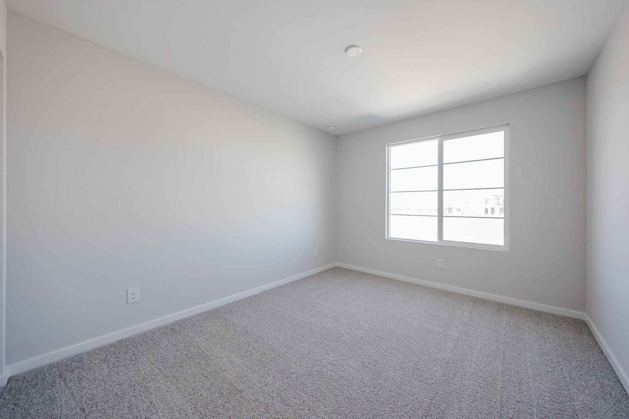 A room with a window and carpet.