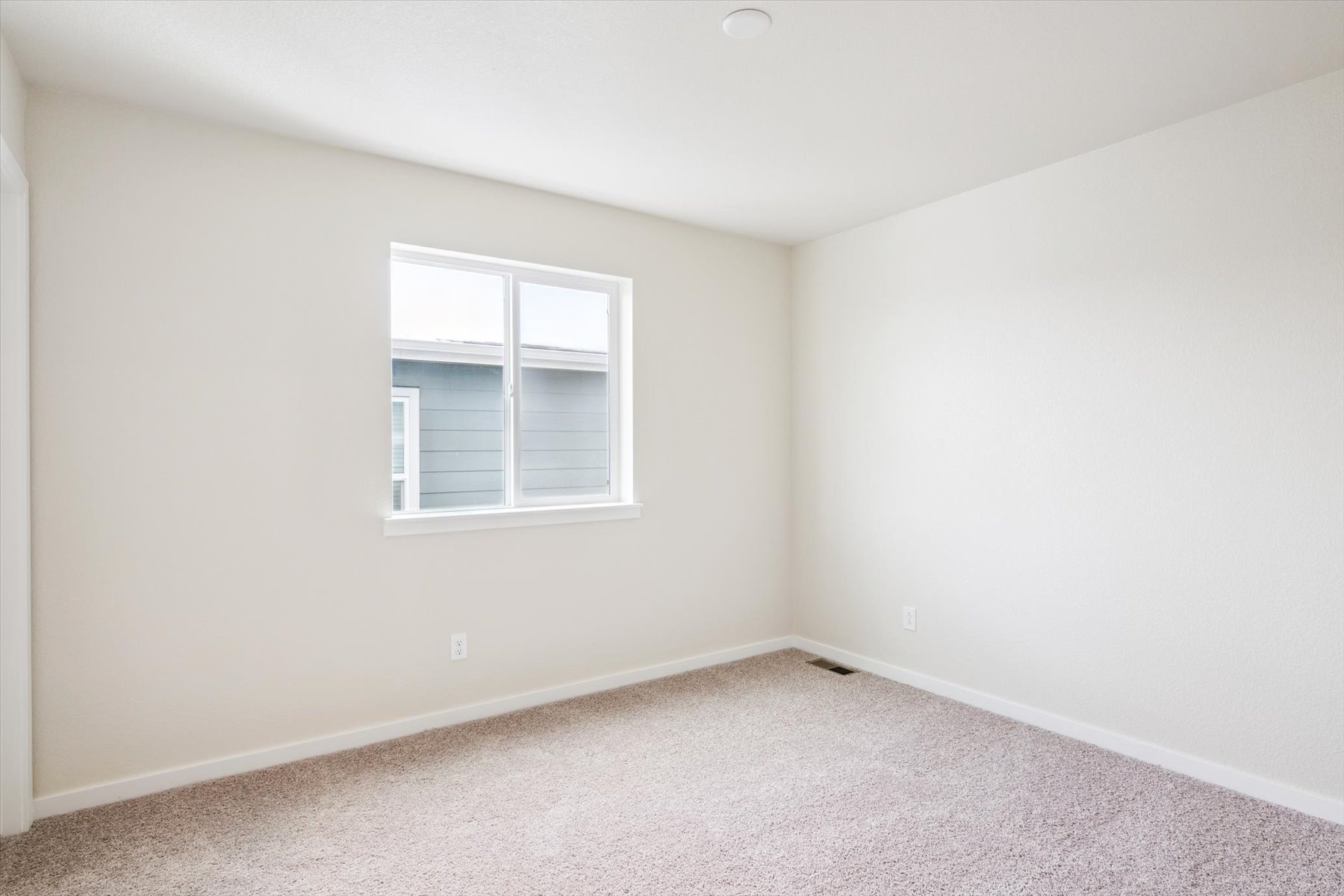 A room with a window and carpet.