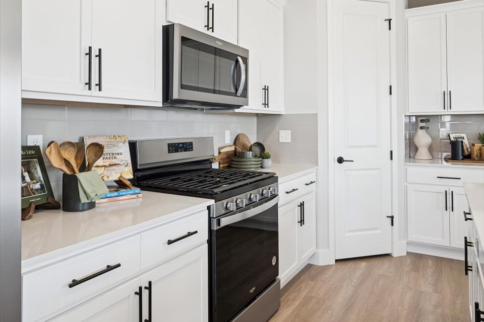 A kitchen with white cabinets.