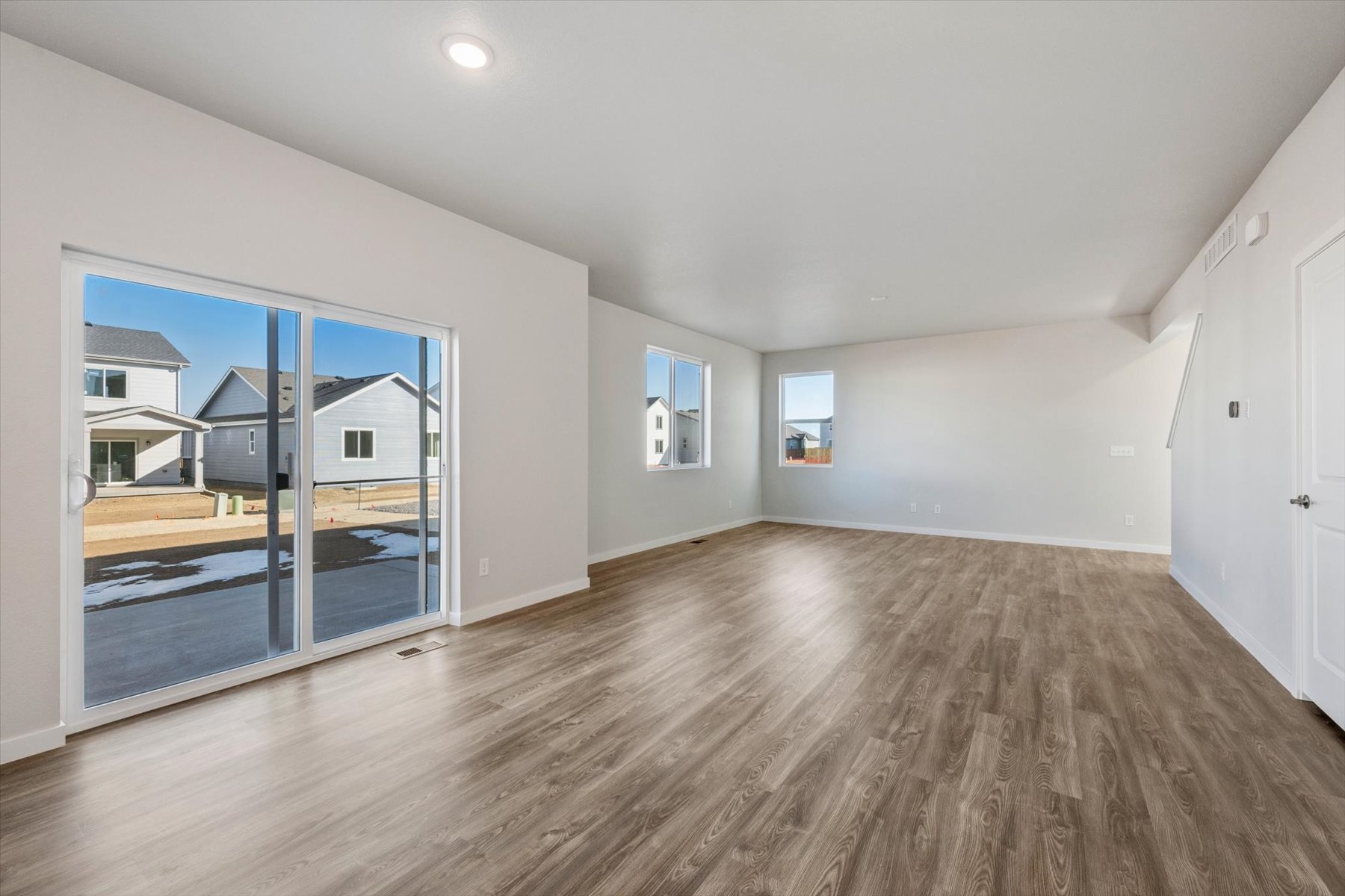A room with a wood floor and a glass door.