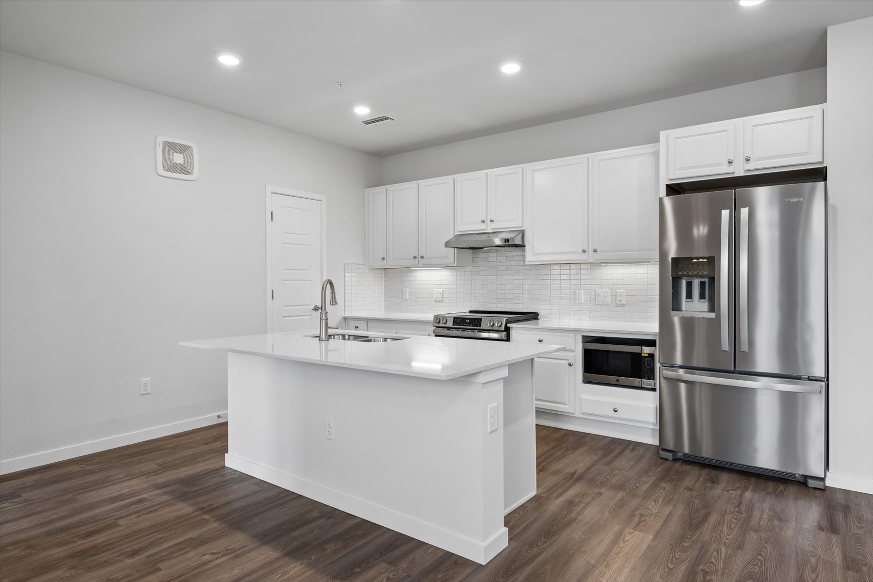 A kitchen with white cabinets.