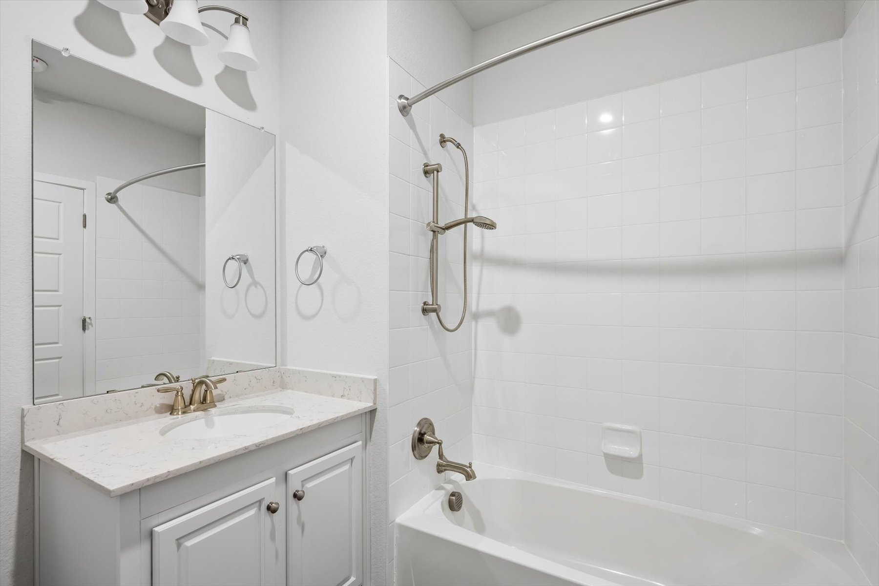 A bathroom with a sink and a shower unit.