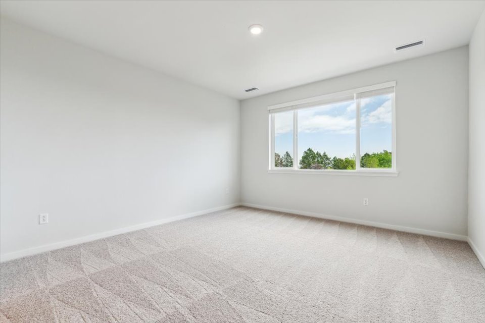 A room with a window and a rug.