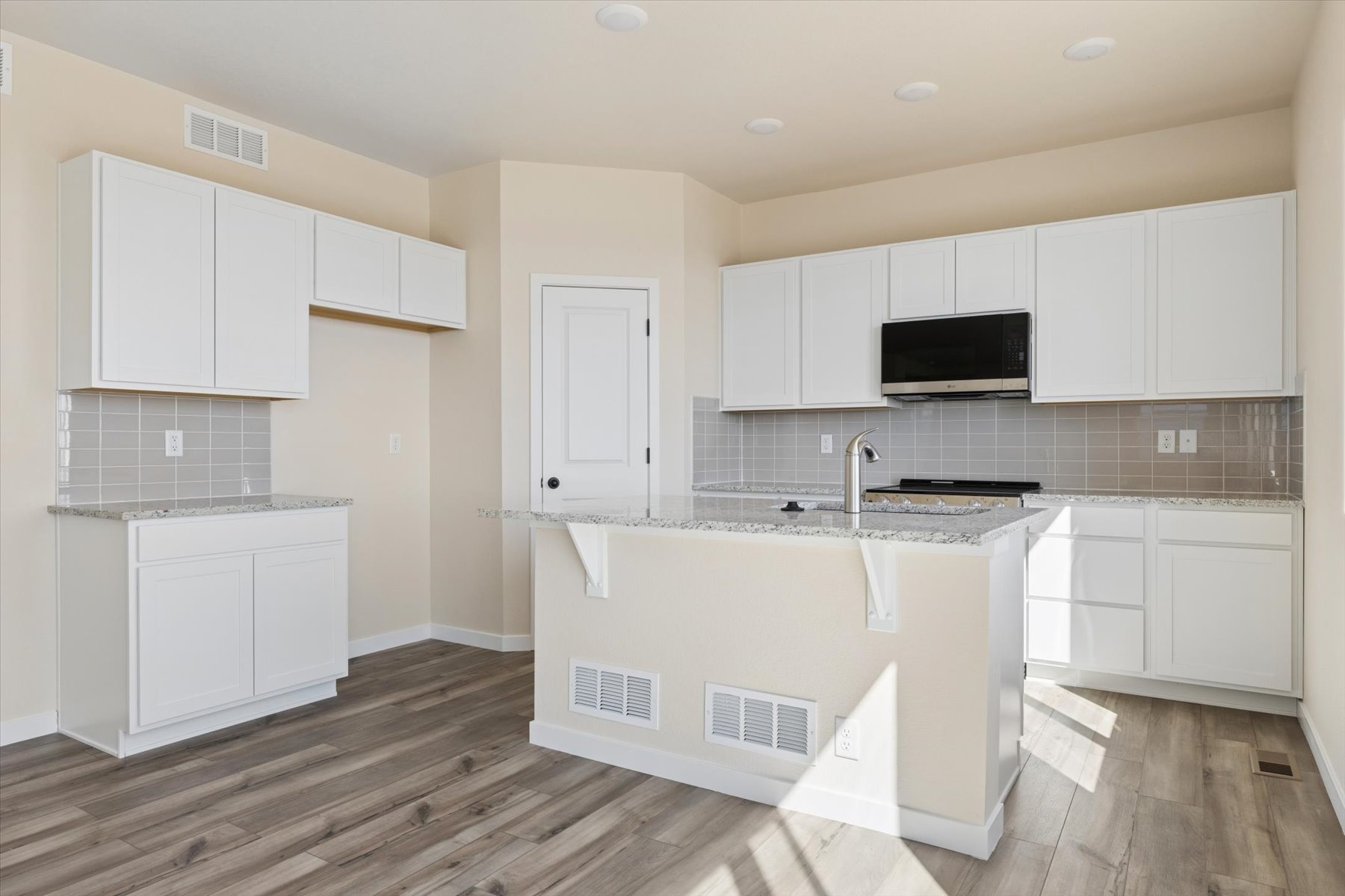 A kitchen with white cabinets.