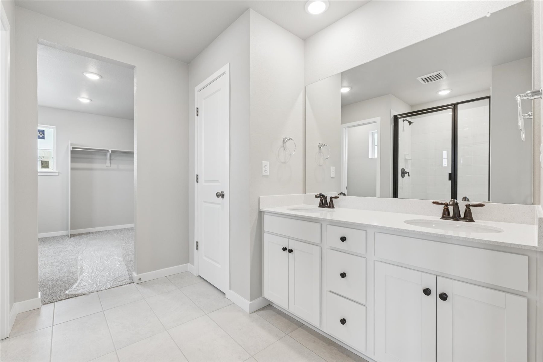 A bathroom with white cabinets.