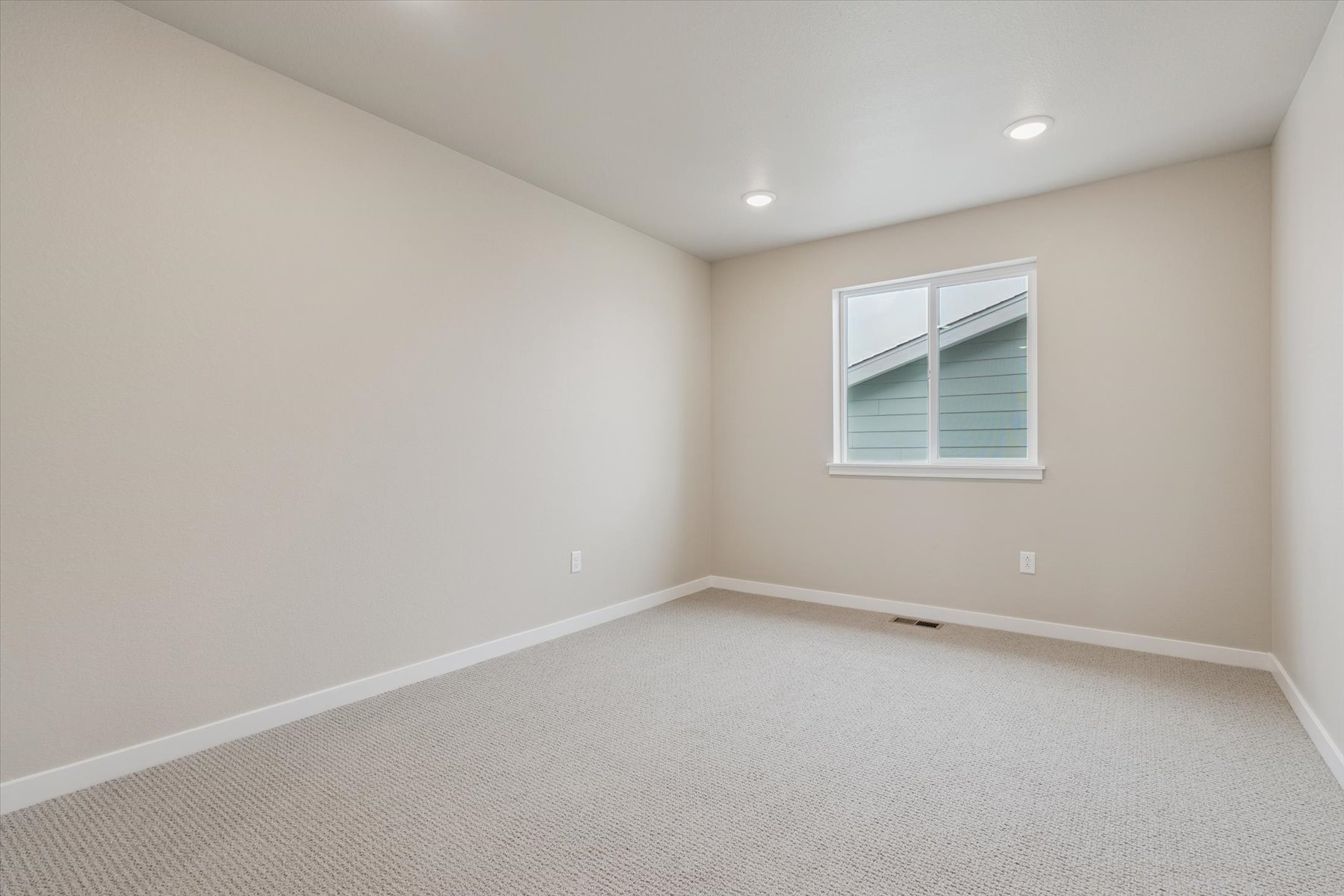 A room with a window and a carpet.