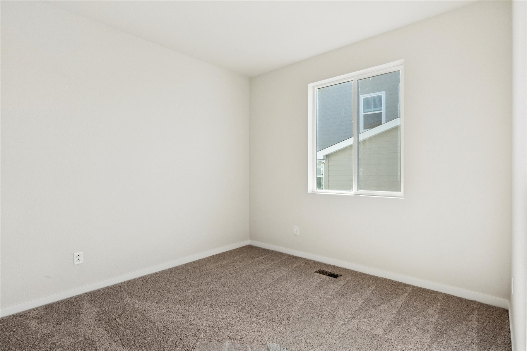 A room with a window and carpet.