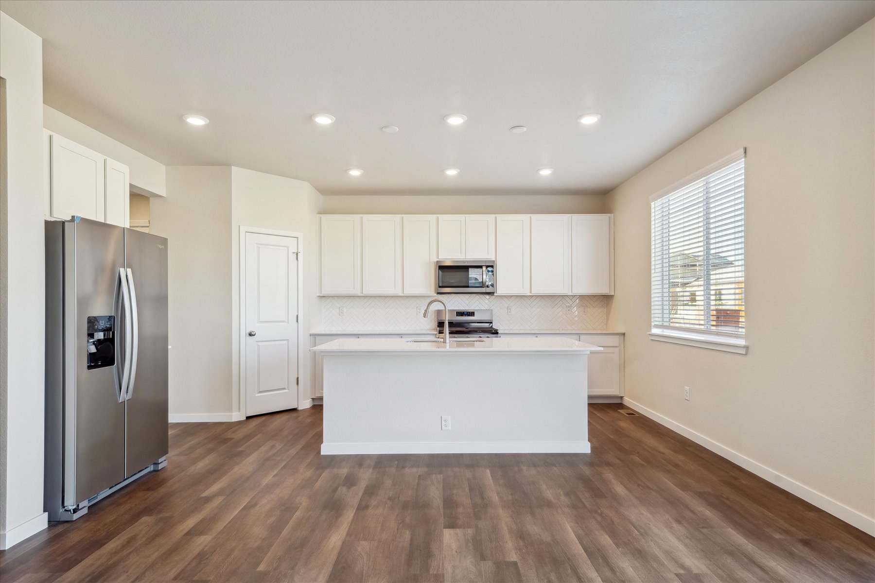 A kitchen with white cabinets.
