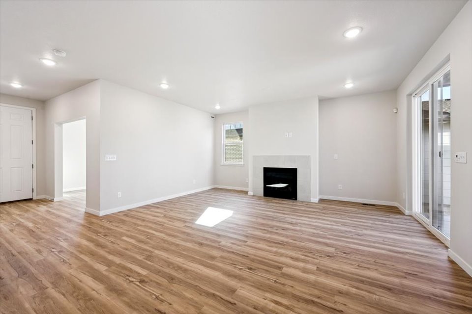 A large empty room with a fireplace.