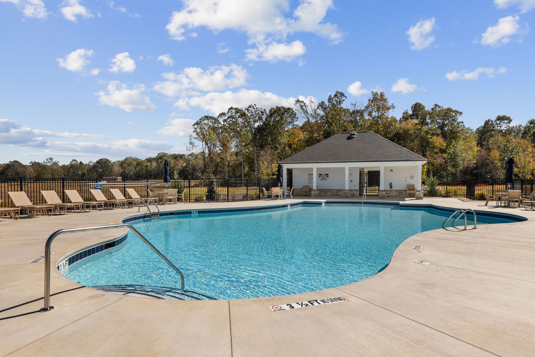 A swimming pool with a house in the background.