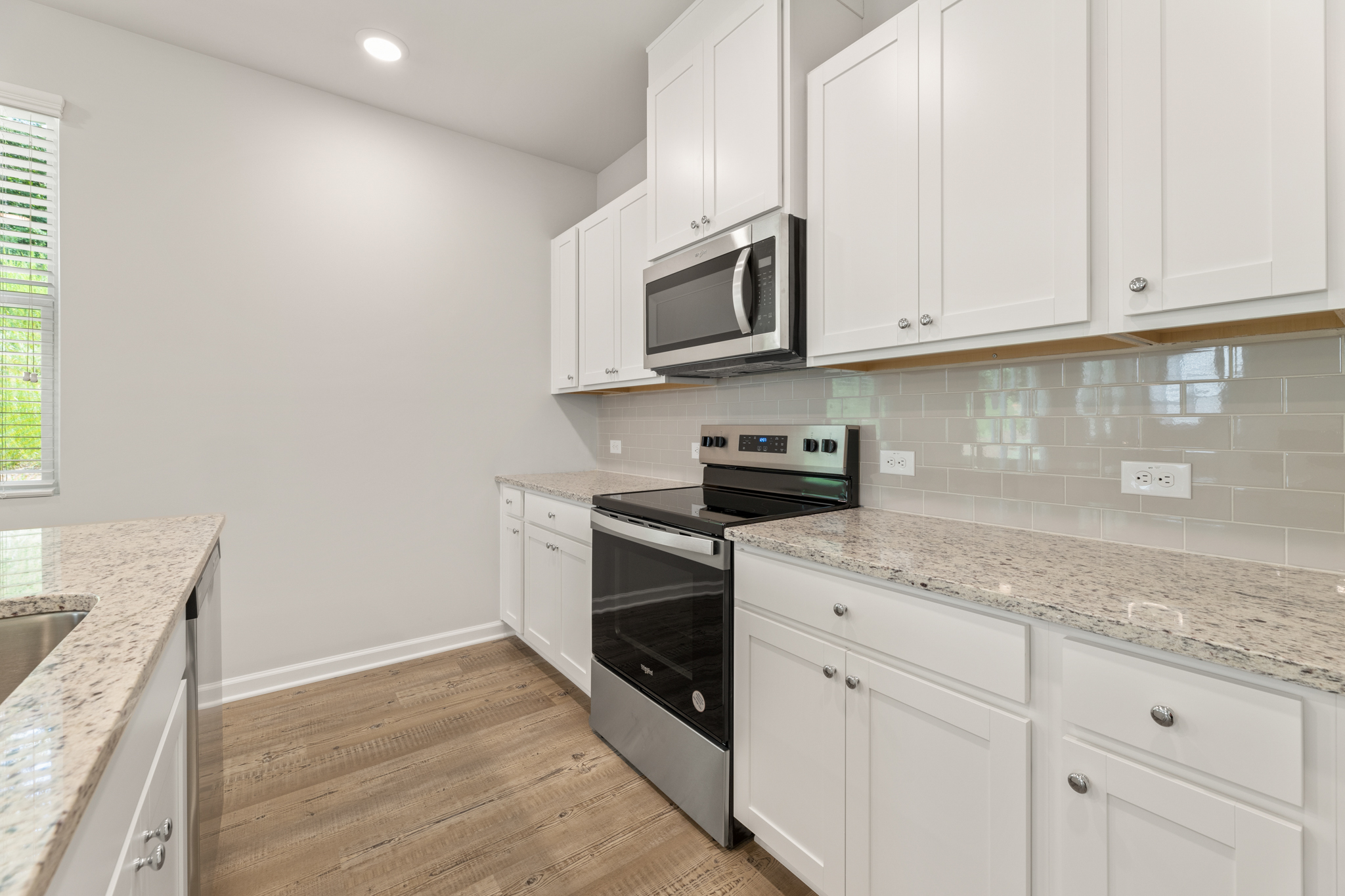 A kitchen with white cabinets.