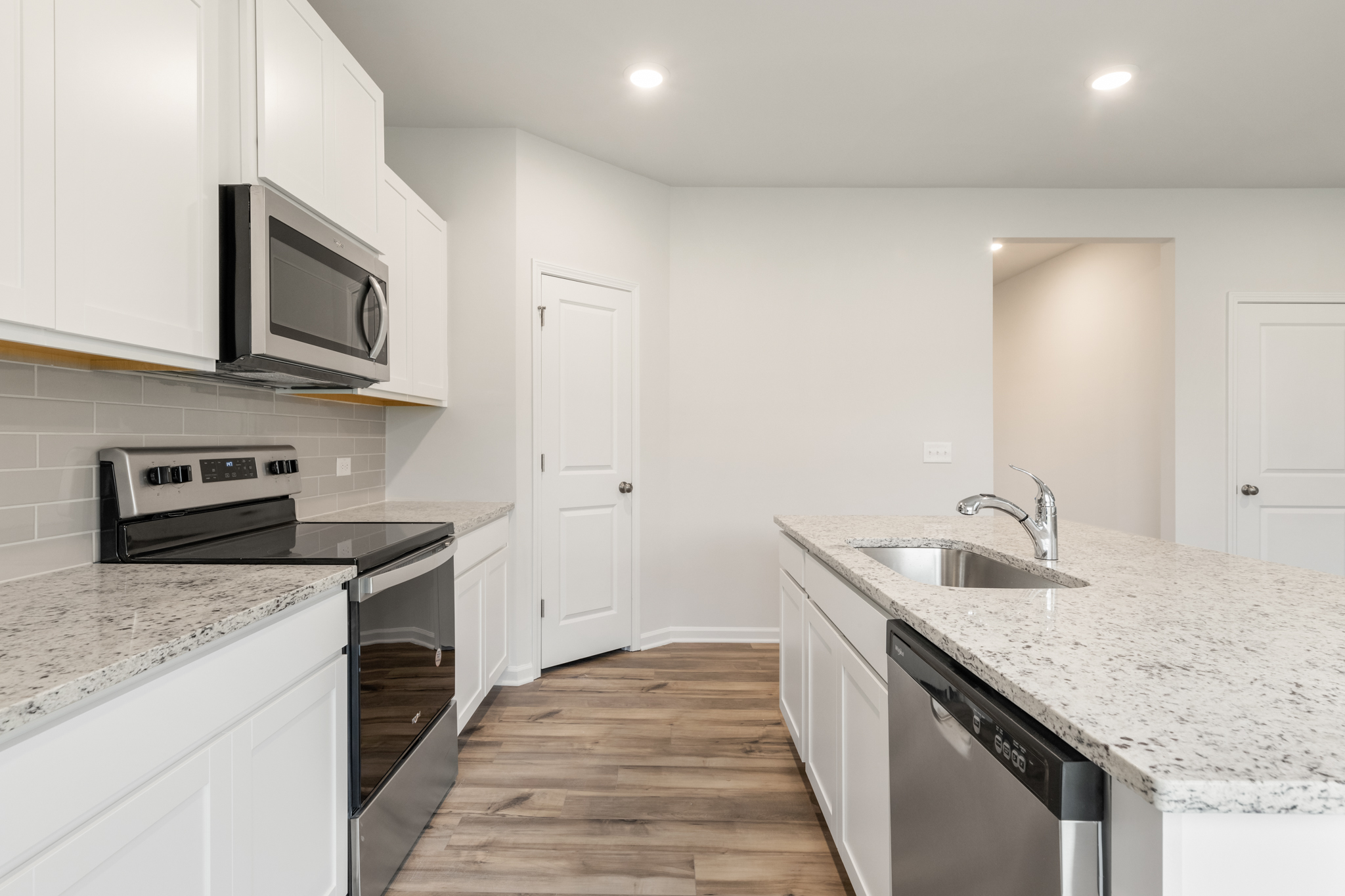 A kitchen with white cabinets.