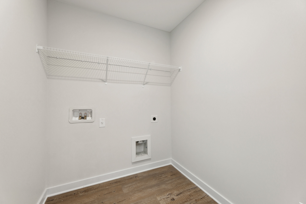 A white room with a wood floor.