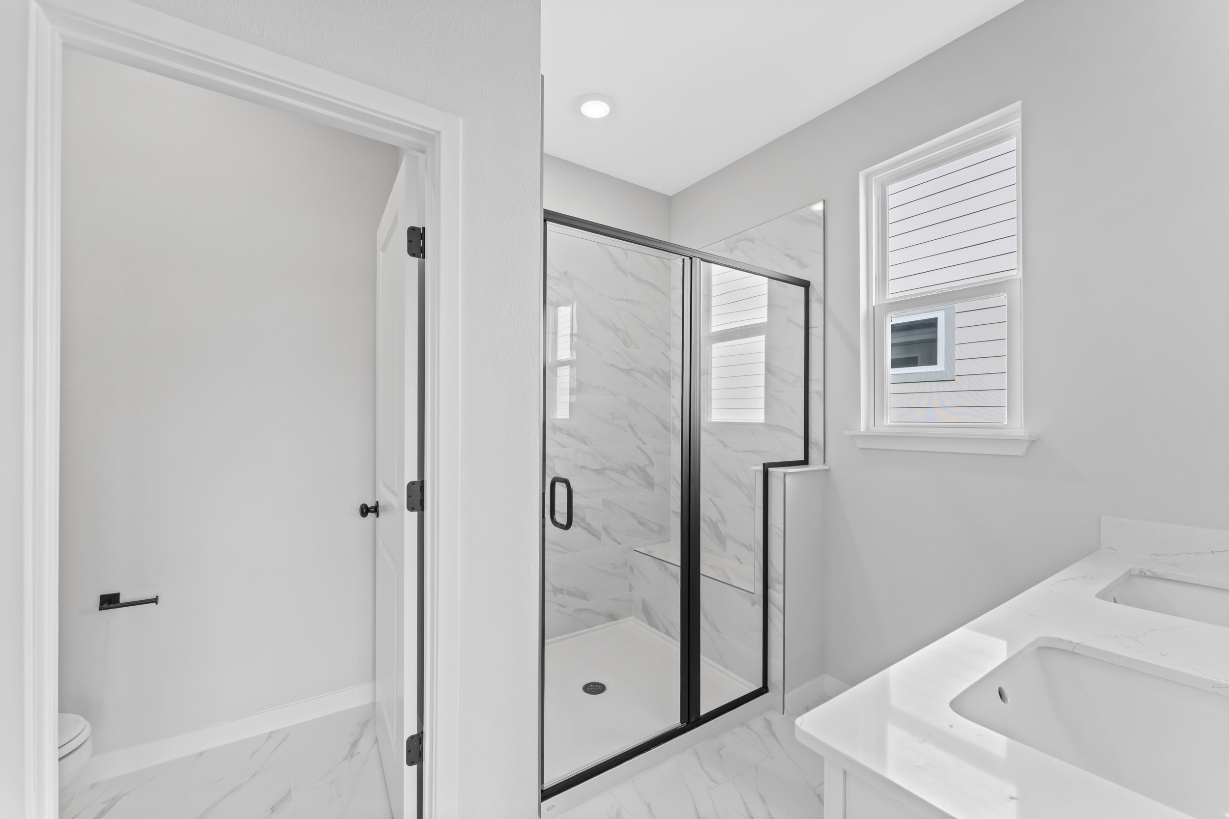 Miramar Floorplan Lot 81 Primary Bathroom with Glass Shower and Dual Vanity Sink at Concourse Crossing in Fernandina Beach