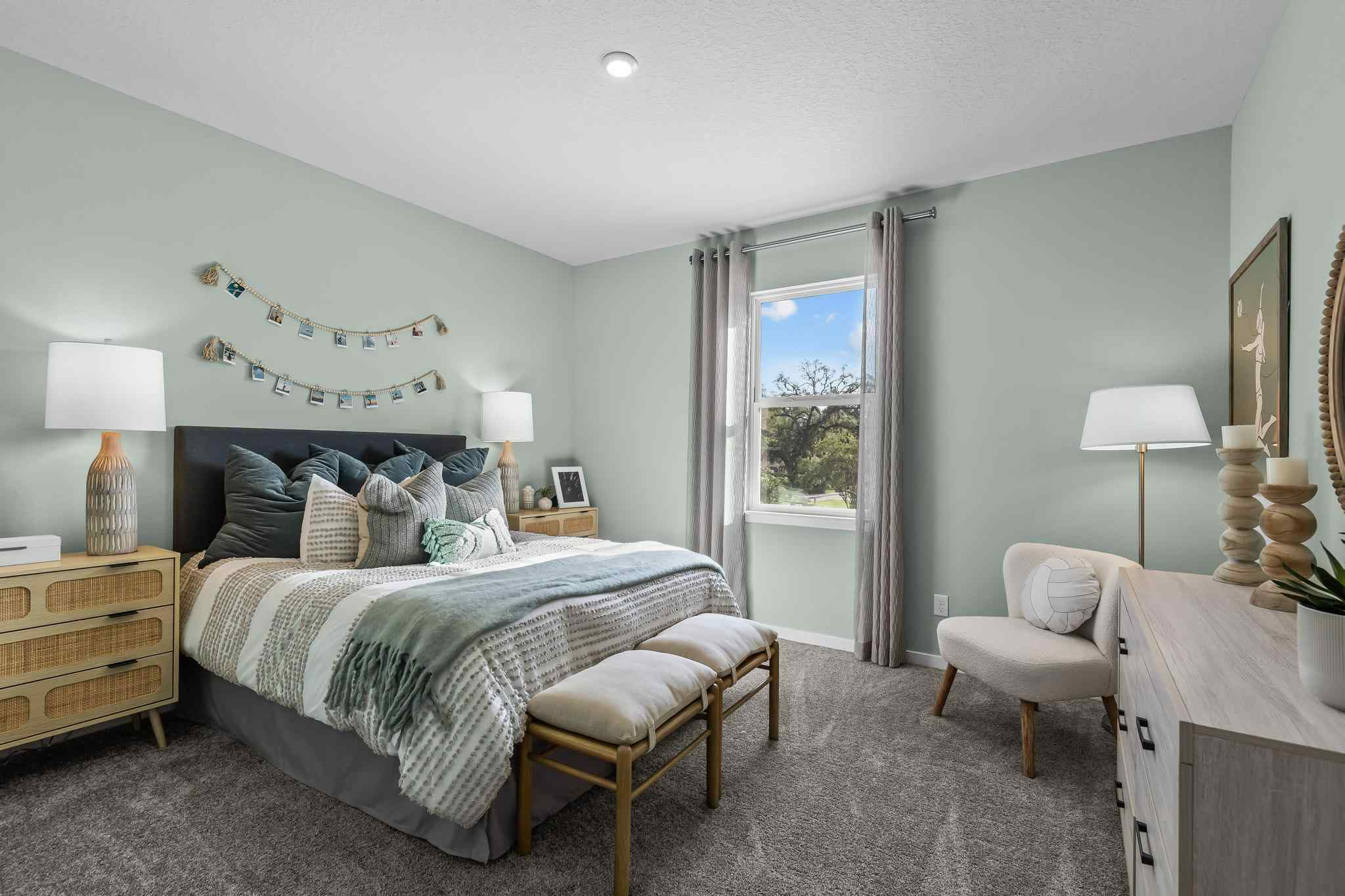 A bedroom with a bed and chairs.