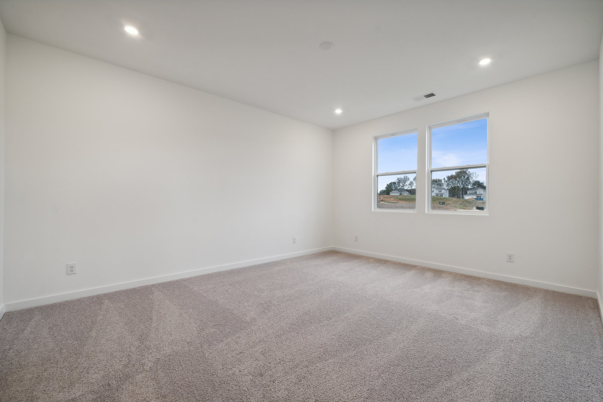 A room with a carpet and windows.