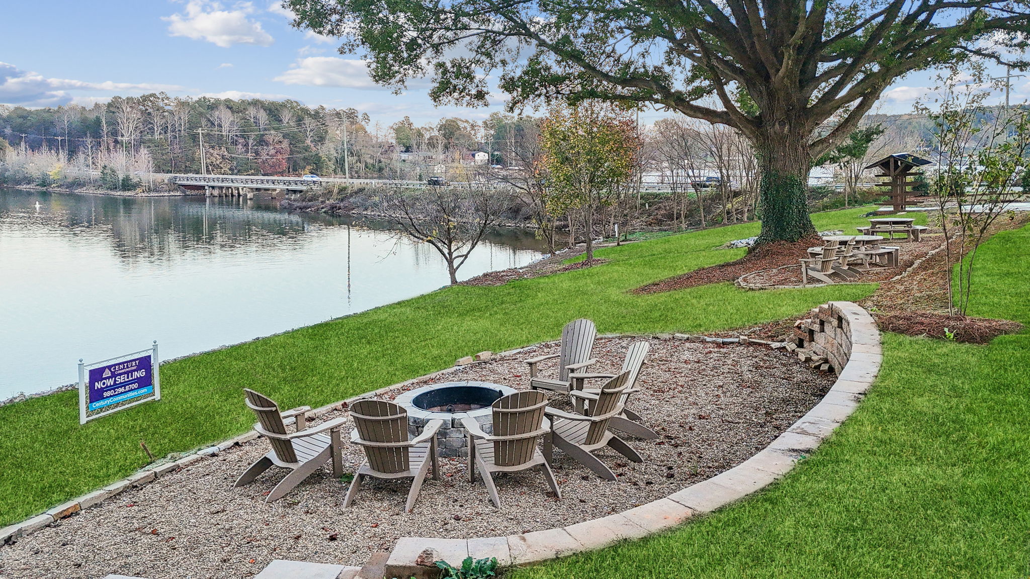 A table and chairs next to a lake.