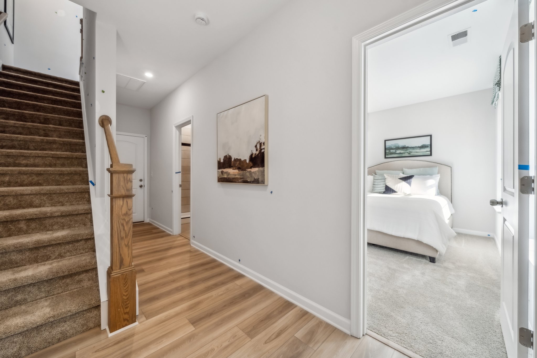 A room with a bed and a wood floor.