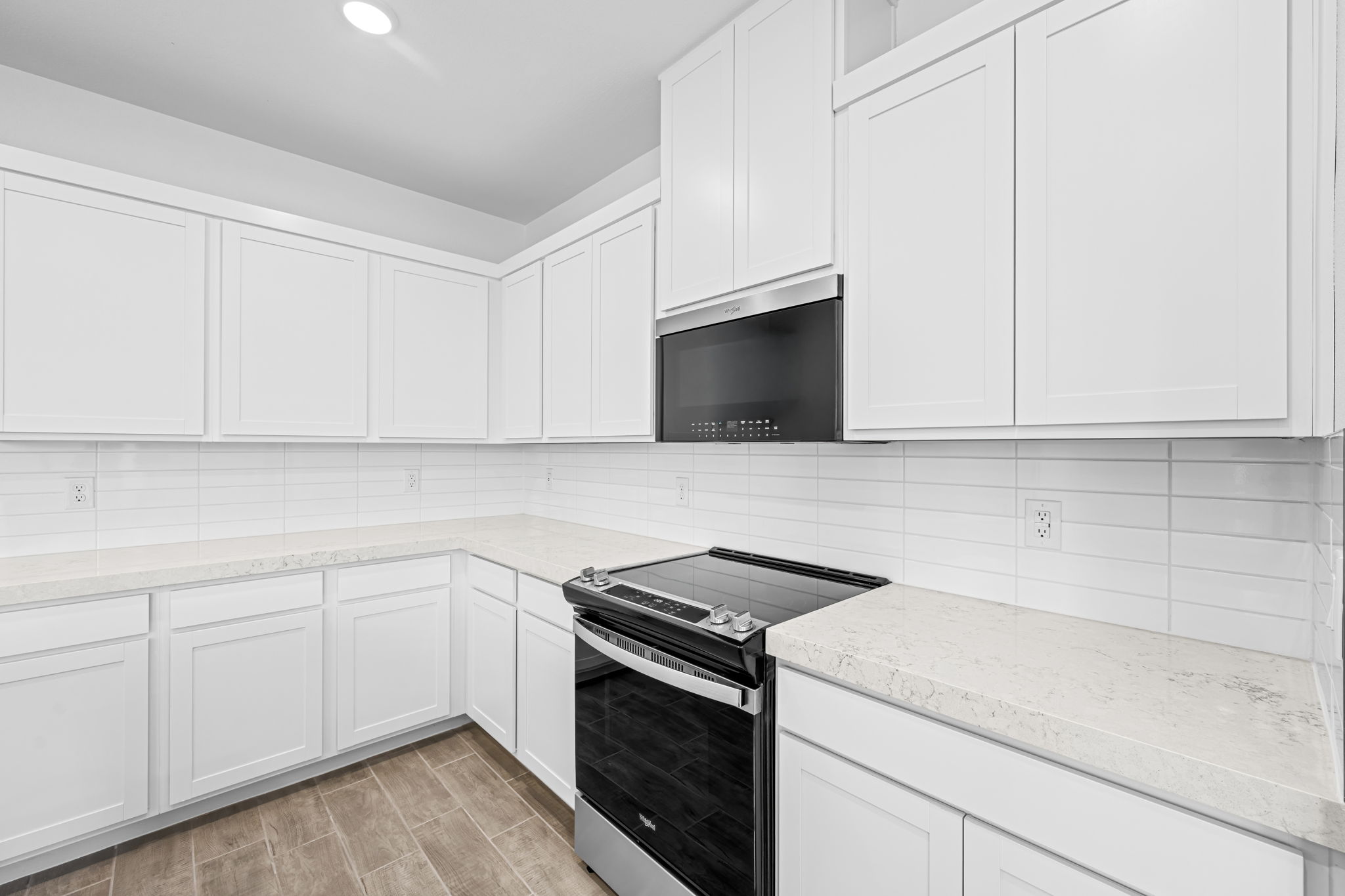 A kitchen with white cabinets.
