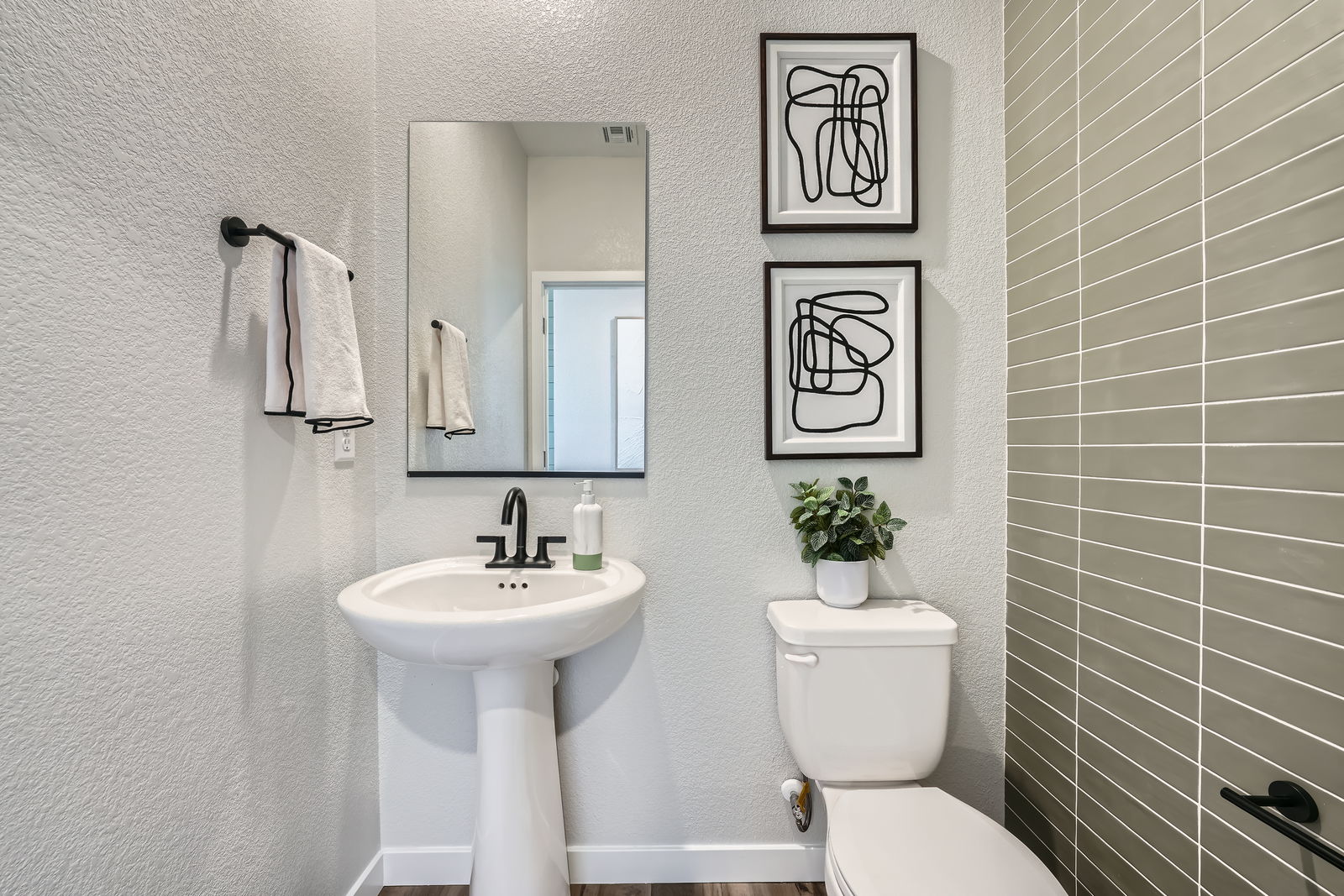 A bathroom with a sink toilet and mirror.