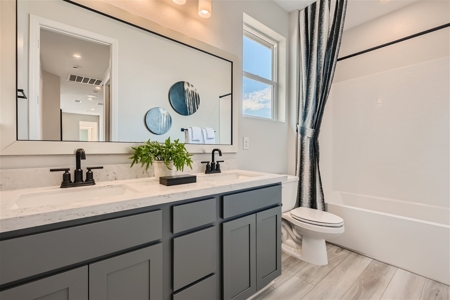 A bathroom with a sink toilet and mirror.