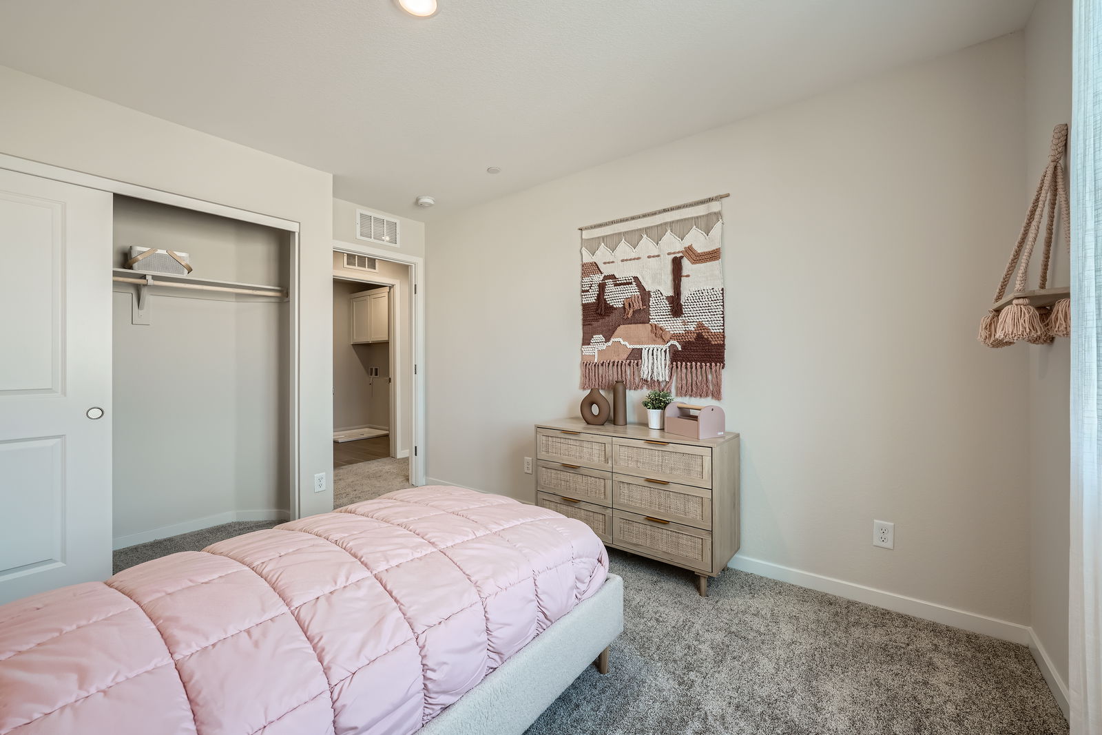 A bedroom with a pink bed.
