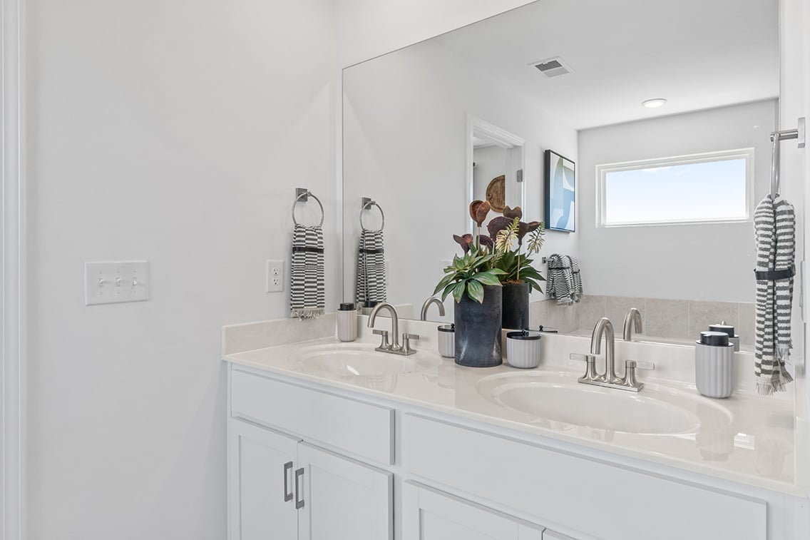 A person taking a selfie in the bathroom mirror.