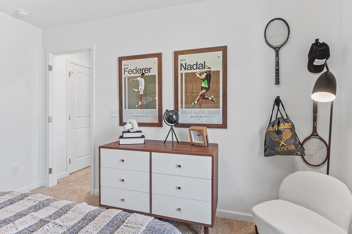 A room with a white chair and a white door with a picture on it.