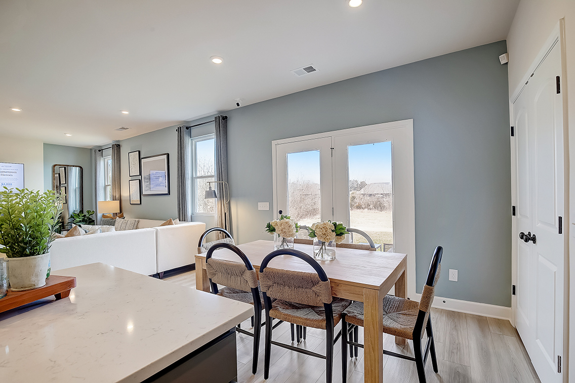 A kitchen with a dining table and chairs.