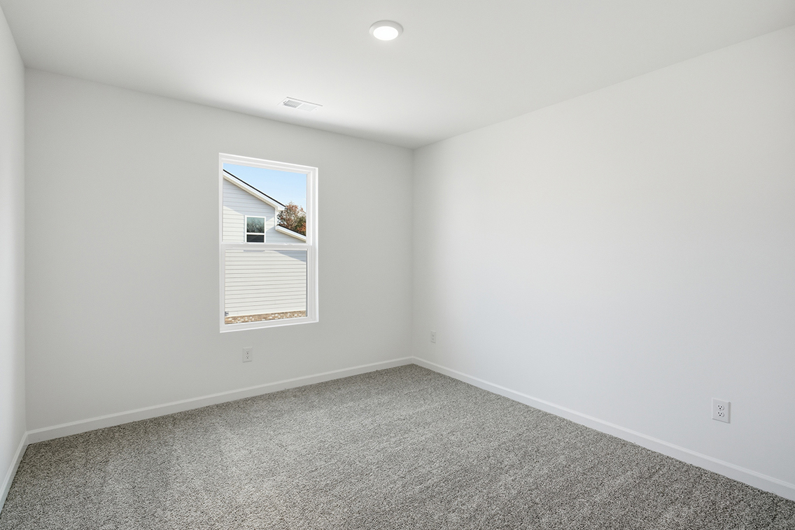 A room with a window and a carpet.