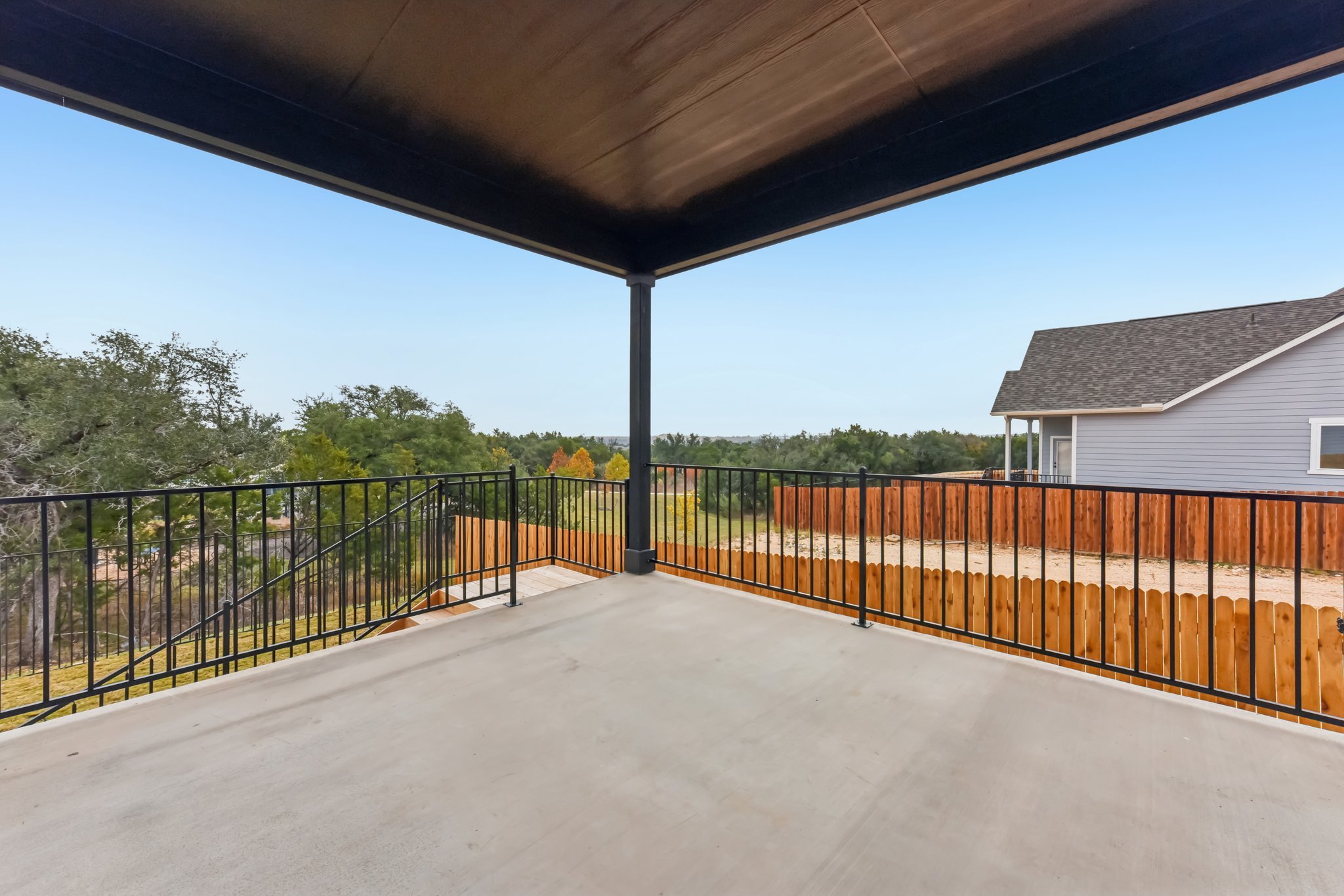 A walkway with a fence and trees.