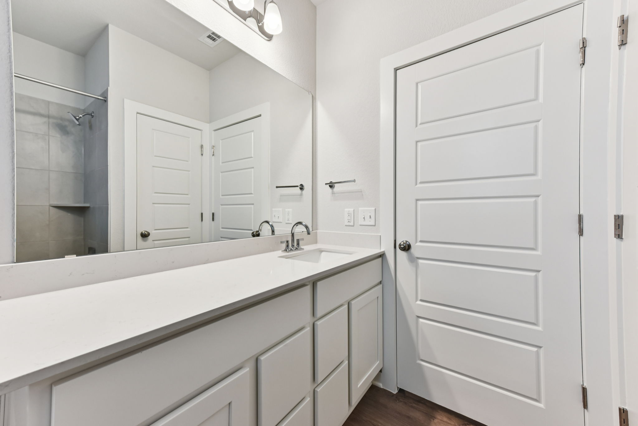 A bathroom with white cabinets.