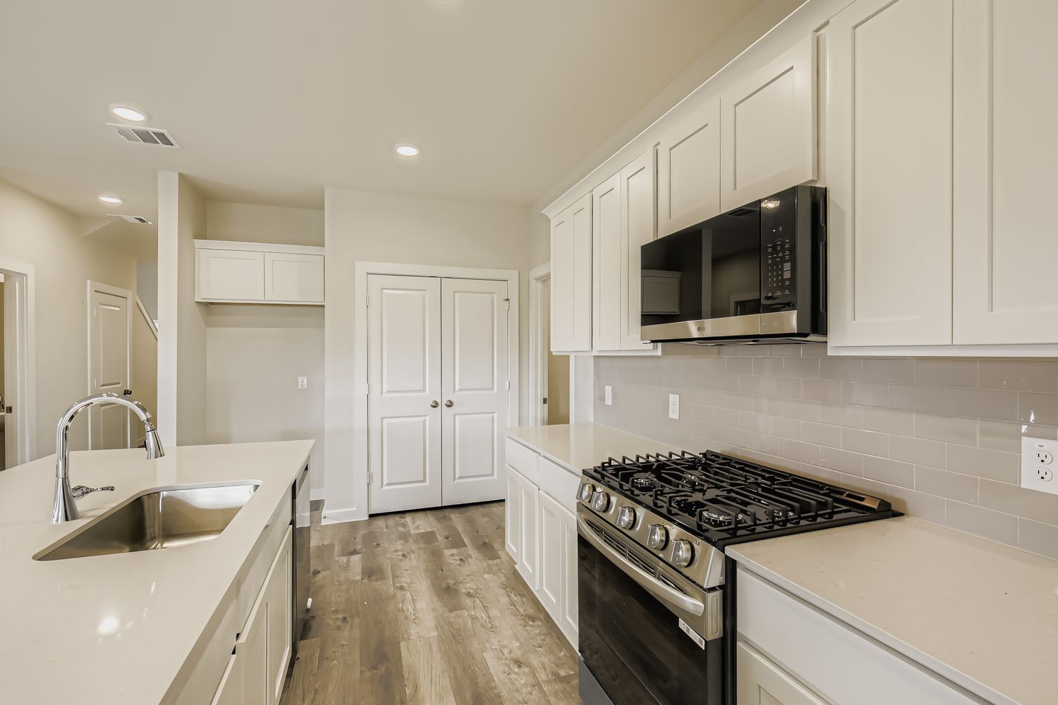 A kitchen with white cabinets.