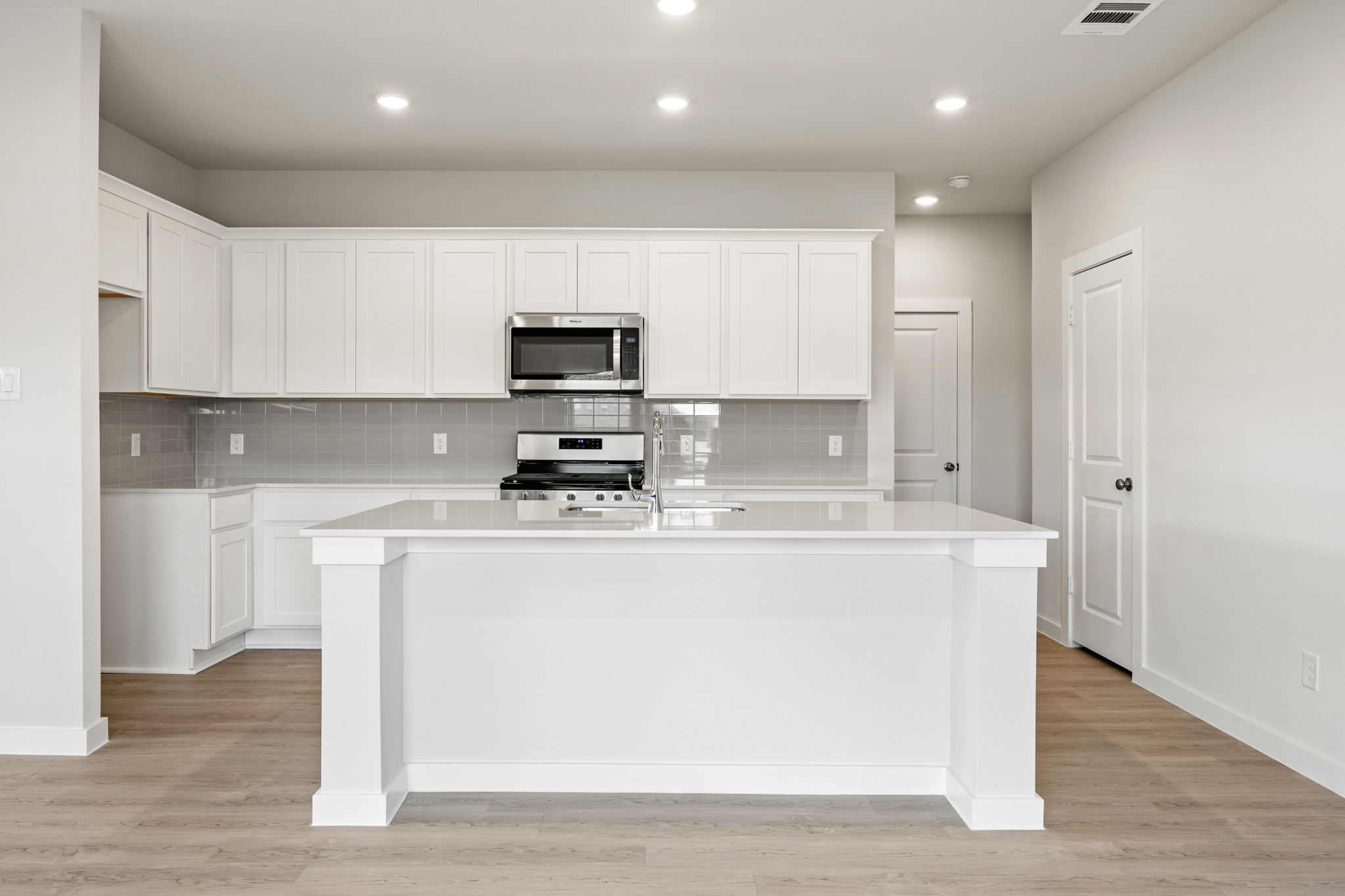 A kitchen with white cabinets.