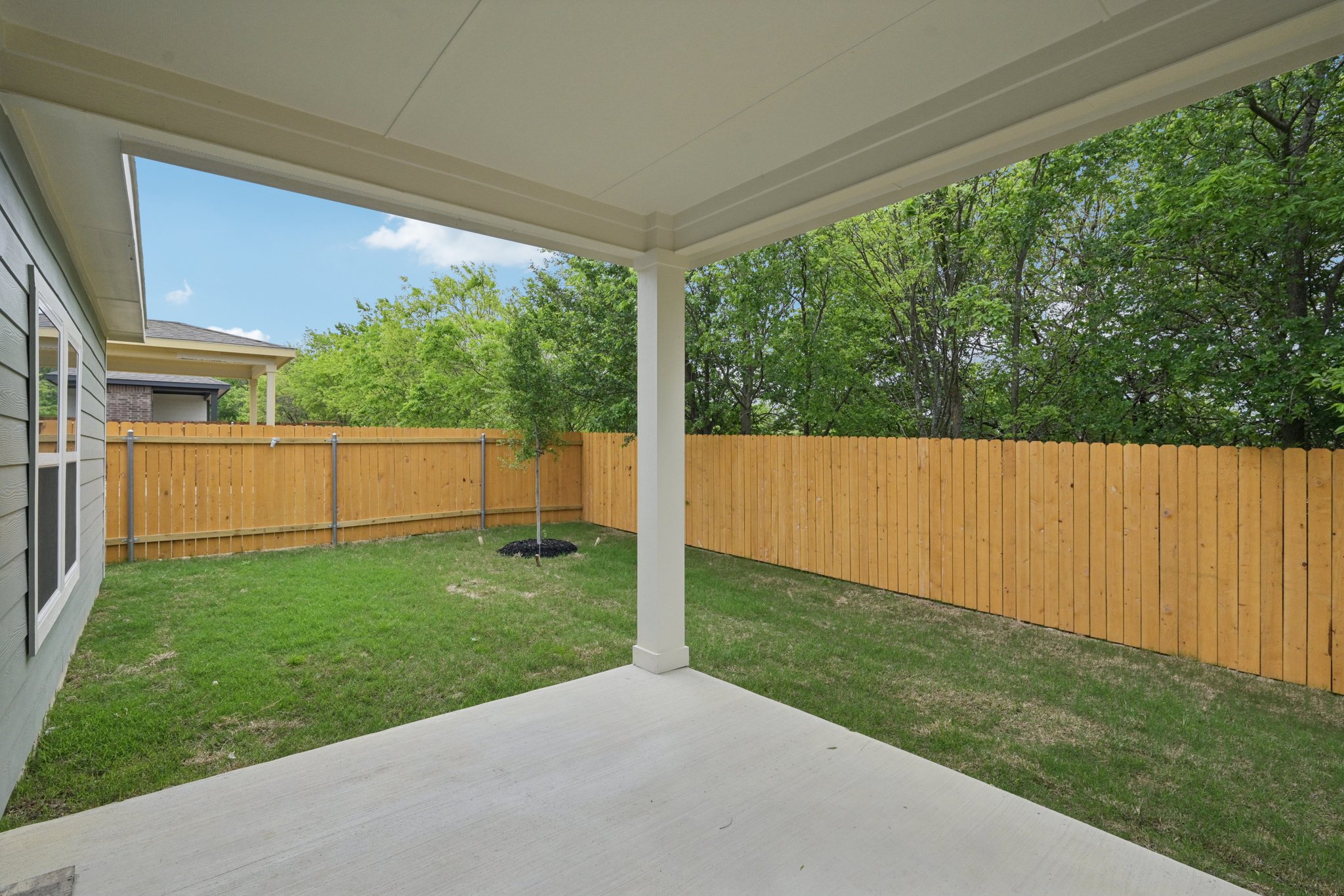 A fenced in yard with a wood fence and trees.