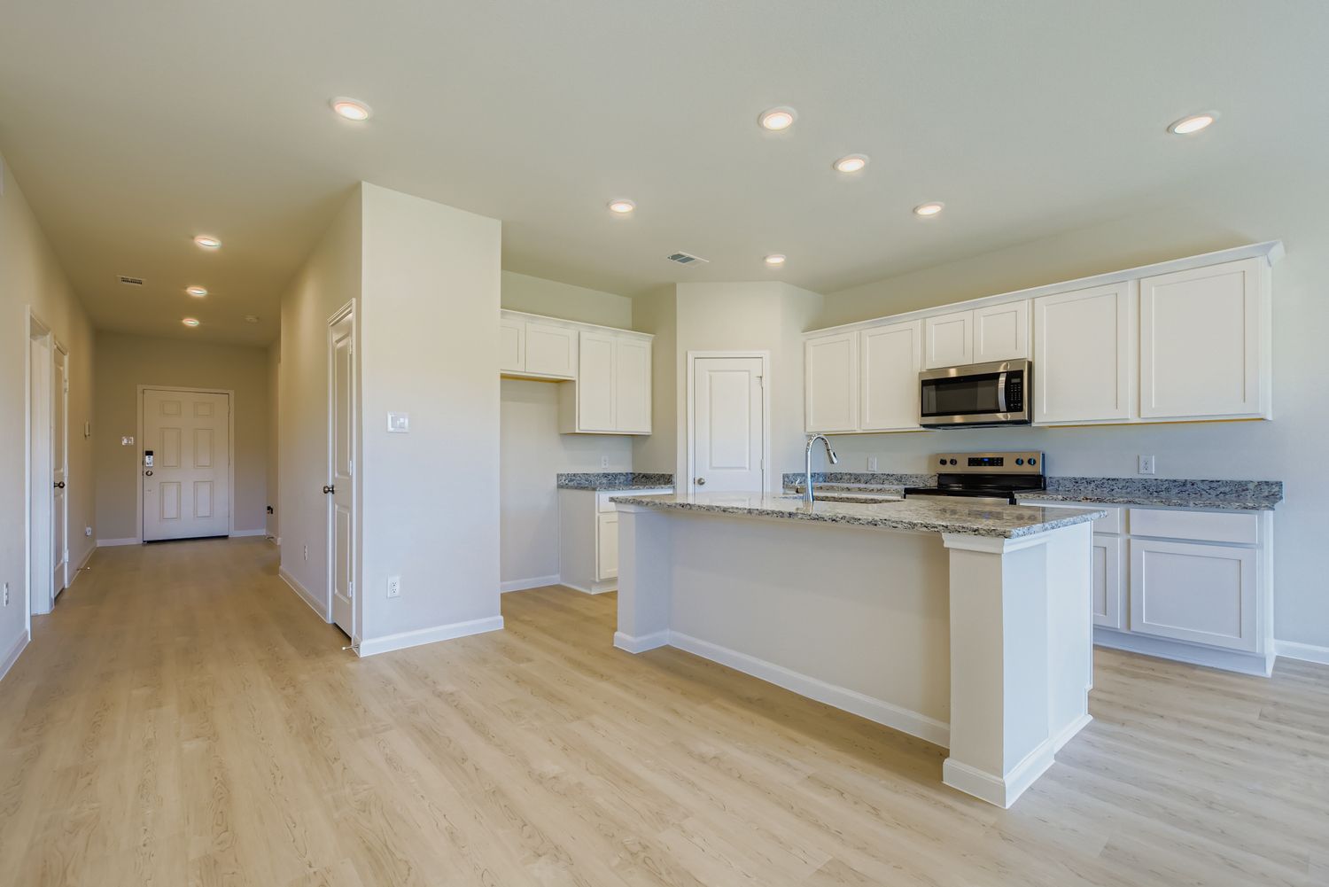 A kitchen with white cabinets.