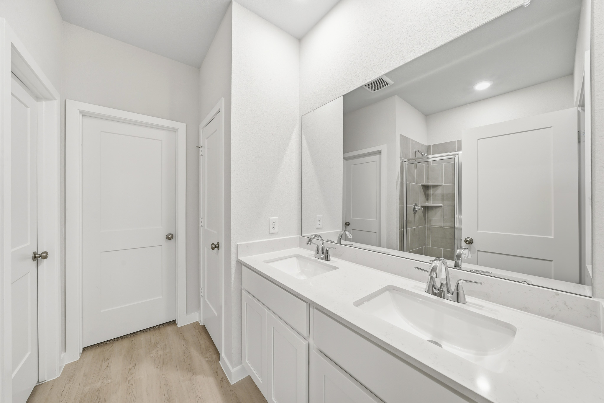 A bathroom with white cabinets.
